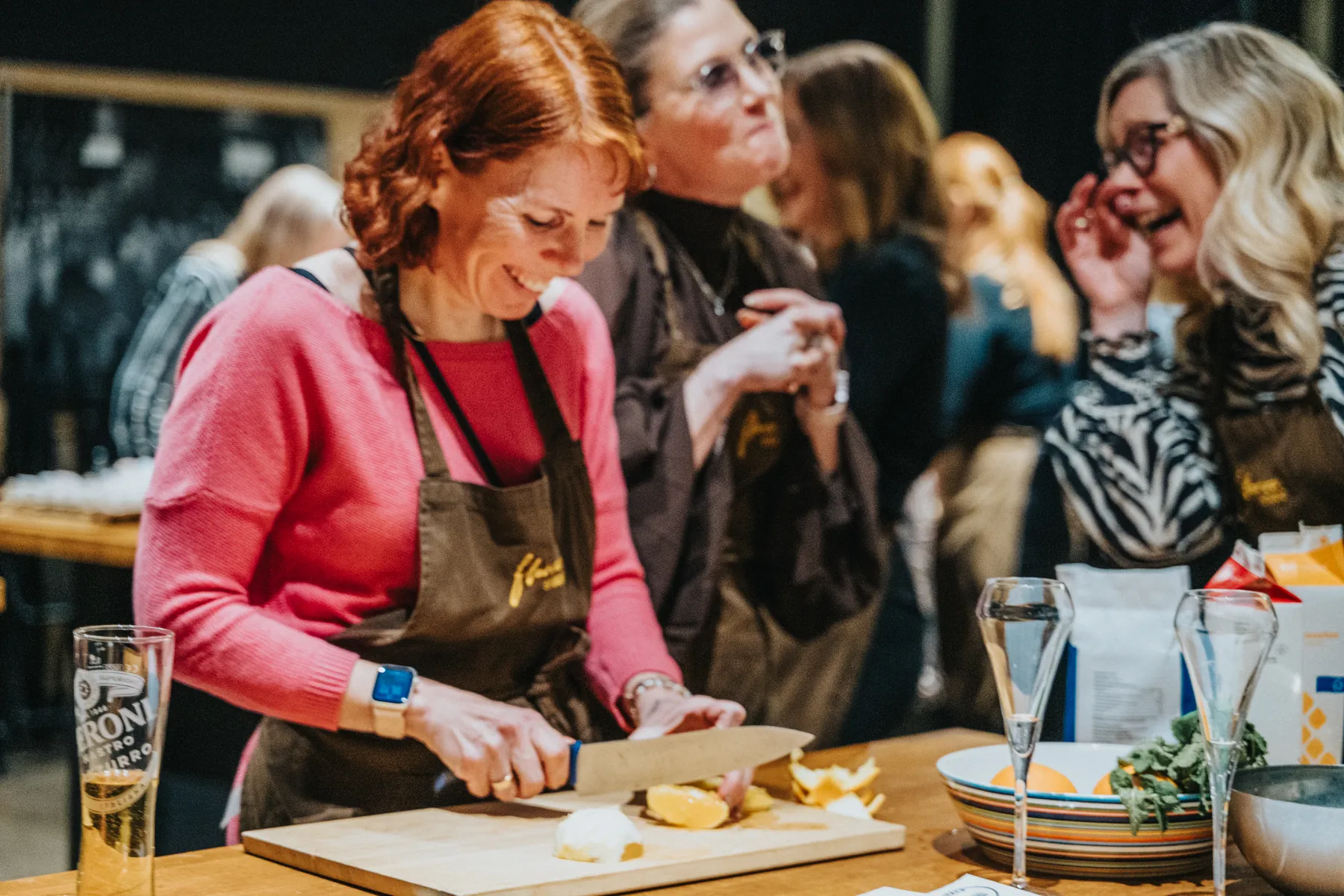 Guests cooking and laughing at a station.
